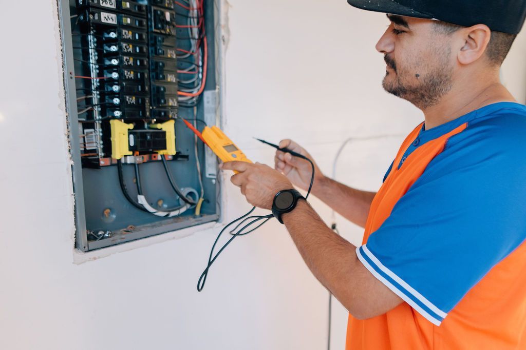A Defused Electrical technician testing an electrical panel with a multimeter