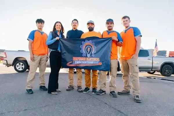 The Defused Electrical Innovations team with the company banner